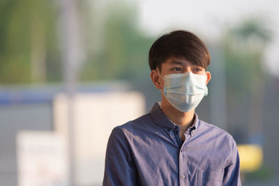 Teenage boy wearing mask standing outdoors