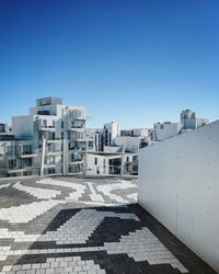 View of residential buildings against clear blue sky