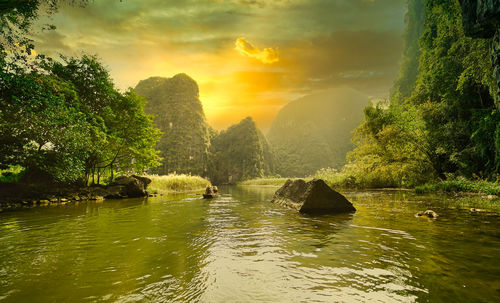 Scenic view of river against sky during sunset