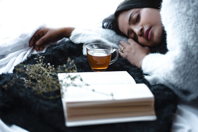 Midsection of woman drinking glass on table