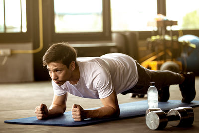 Full length of senior man sitting on window