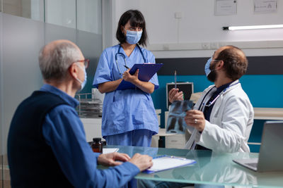 Side view of doctor examining patient at clinic