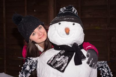 Portrait of smiling girl with snowman during christmas