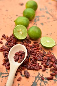 Cool green limes hot red dried chili peppers on rustic tabletop