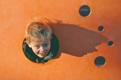 Portrait of cute boy playing against wall