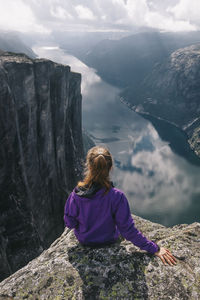 Rear view of woman looking at mountains against sky
