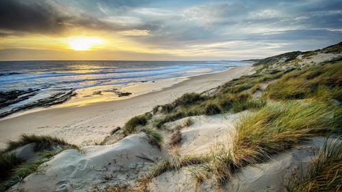 Scenic view of beach against sky during sunset