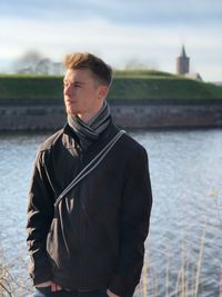 Young man standing on riverbank