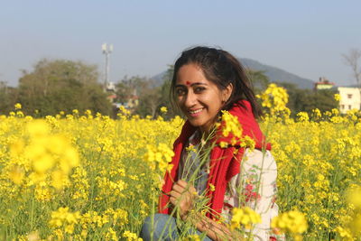 Portrait of smiling young woman standing on field