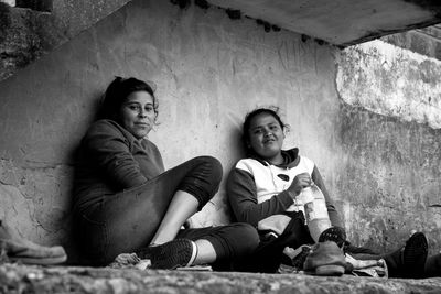 Portrait of women sitting underneath staircase