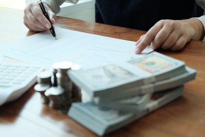 Midsection of man reading book on table