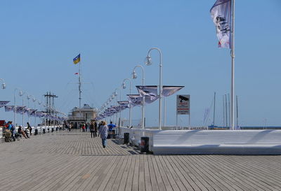 People at beach against clear sky