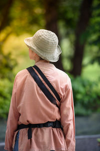 Rear view of man standing against trees