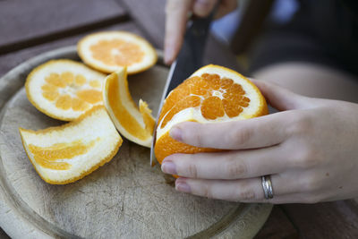 Midsection of woman cutting fruit