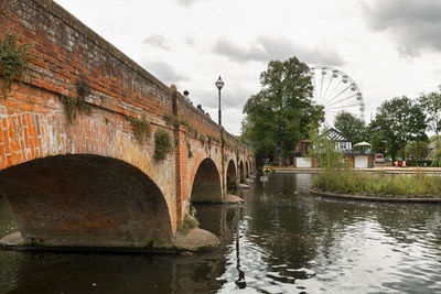 Arch bridge over river against sky