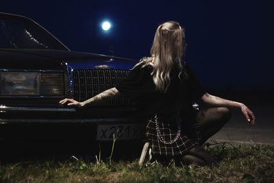 Rear view of woman sitting on stage at night