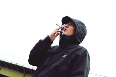 Low angle view of man smoking cigarette