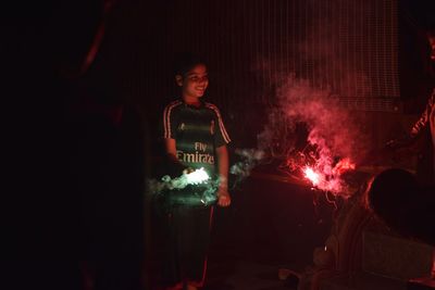 Happy children playing with fireworks at night