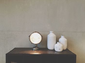 Illuminated decoration and containers on cabinet against wall