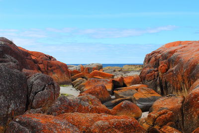 Rock formations by sea against sky