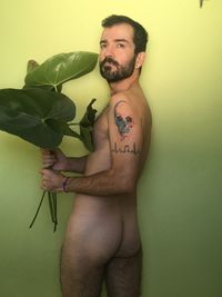 Portrait of young man standing against wall