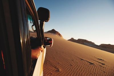 Car on desert against sky