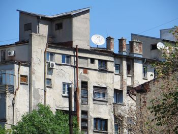 Low angle view of old residential buildings against clear blue sky