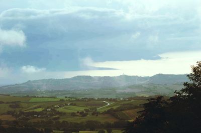 Scenic view of mountains against cloudy sky