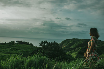 Woman standing by plants against sky