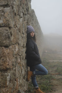 Young girl hatched on a stone wall