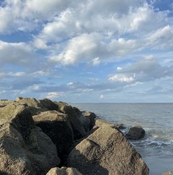 Rock formations on sea shore against sky