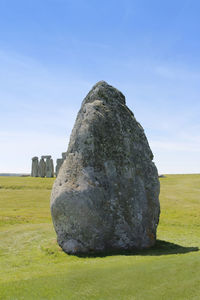 Rock on field against sky