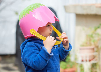 Cute toddler boy pretending to be a football player with an easter basket for a helmet