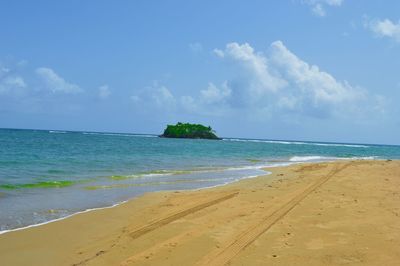 View of calm beach against blue sky