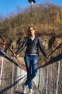 Portrait of young woman standing on footbridge