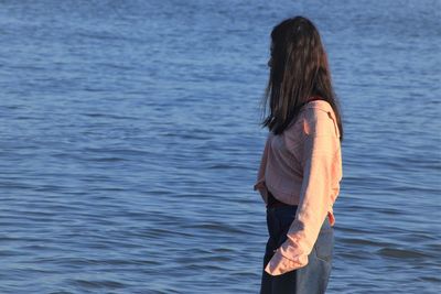 Rear view of woman standing in sea