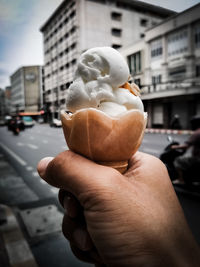 Close-up of hand holding ice cream on street