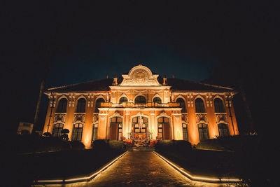 Illuminated building against clear sky at night