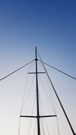 Low angle view of electricity pylon against clear sky