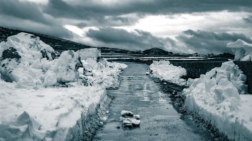 Panoramic view of frozen lake against sky