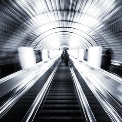 Rear view of people on moving walkway