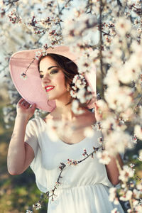 Young woman wearing hat standing at park