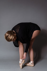 Low section of man standing against gray background