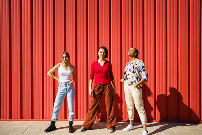 Full length of woman standing against yellow wall