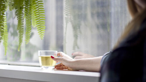 Woman drinking water from glass window