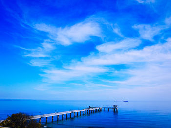 Pier over sea against blue sky