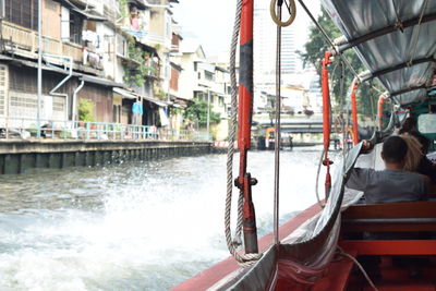 Rear view of men on boat in canal