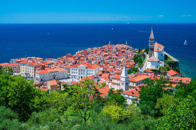 High angle view of townscape by sea against sky