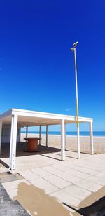 Empty chairs against clear blue sky