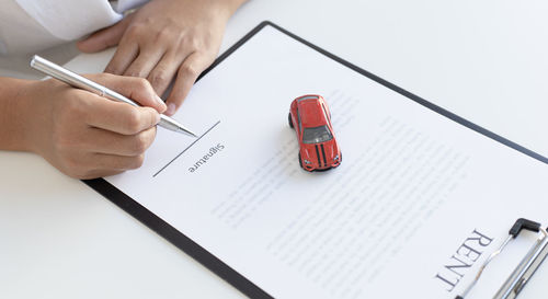 High angle view of hand holding pen on table